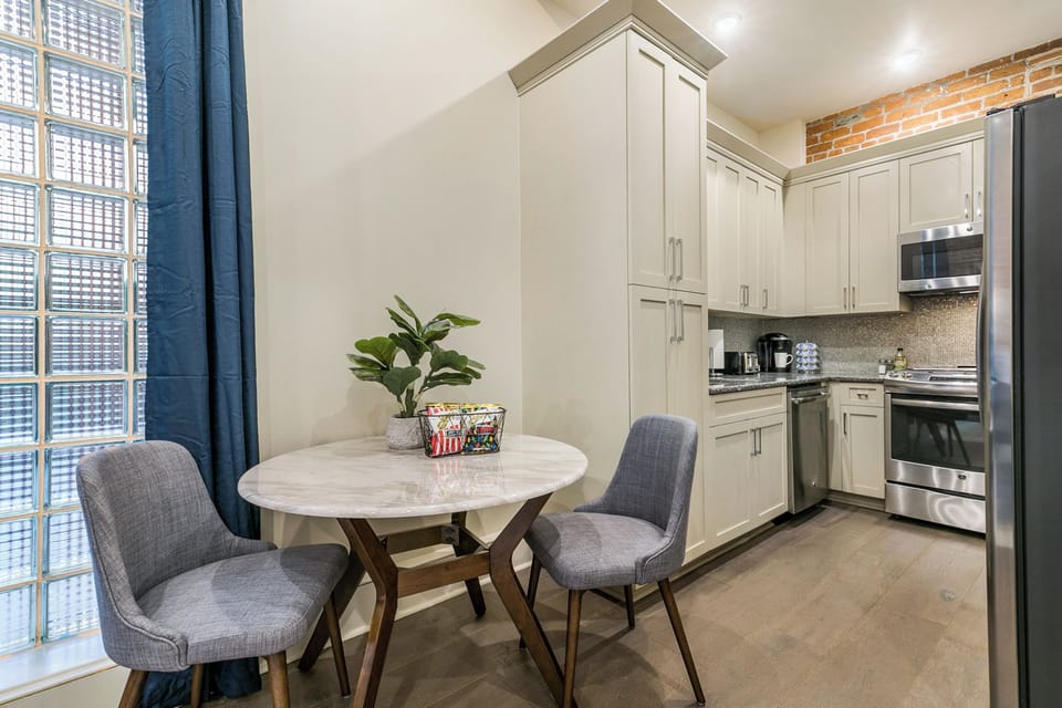 Spacious studio with a king-size bed, twin futon, and designer built-in closet. Features a stocked kitchen, dining area, hangers, white noise machine, and a 50'' Samsung Smart 4K TV with streaming and DIRECTV.