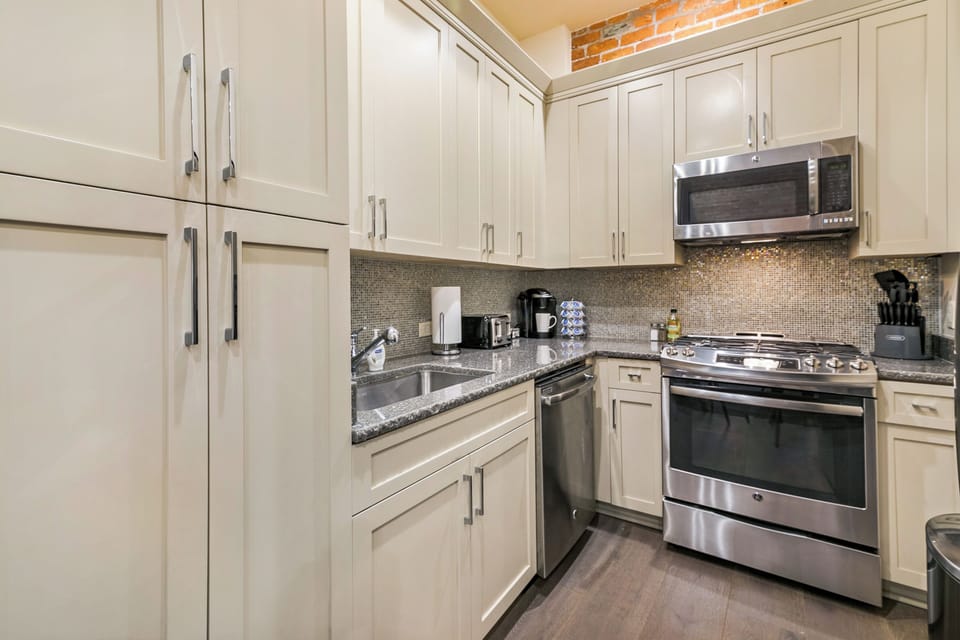 Spacious studio with a king-size bed, twin futon, and designer built-in closet. Features a stocked kitchen, dining area, hangers, white noise machine, and a 50'' Samsung Smart 4K TV with streaming and DIRECTV.