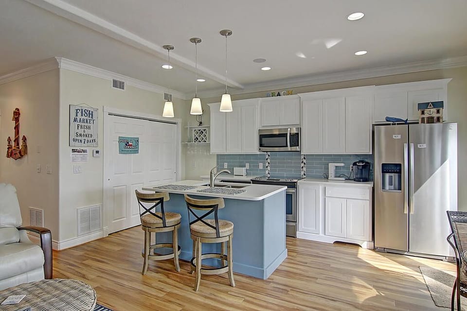 You'll love preparing meals in this bright coastal kitchen with granite counters, stainless appliances, and charming island seating.