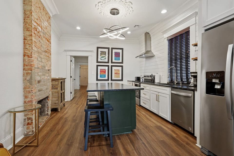 The kitchen blends exposed brick charm with modern appliances and an island for easy meal prep