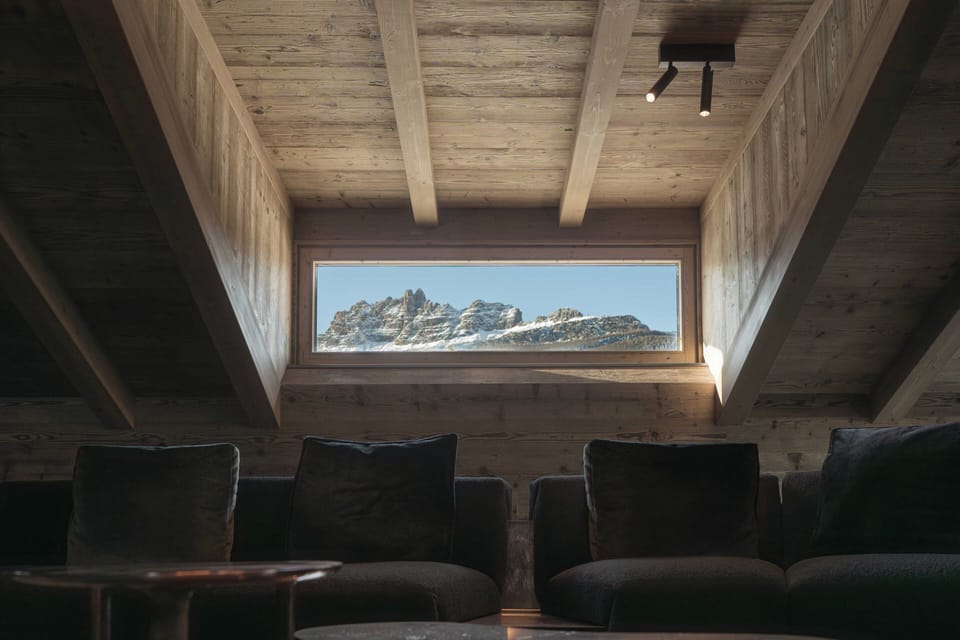 Penthouse with Dolomites view by Henge | Living area | 32-inch flat-screen TV with satellite channels, TV