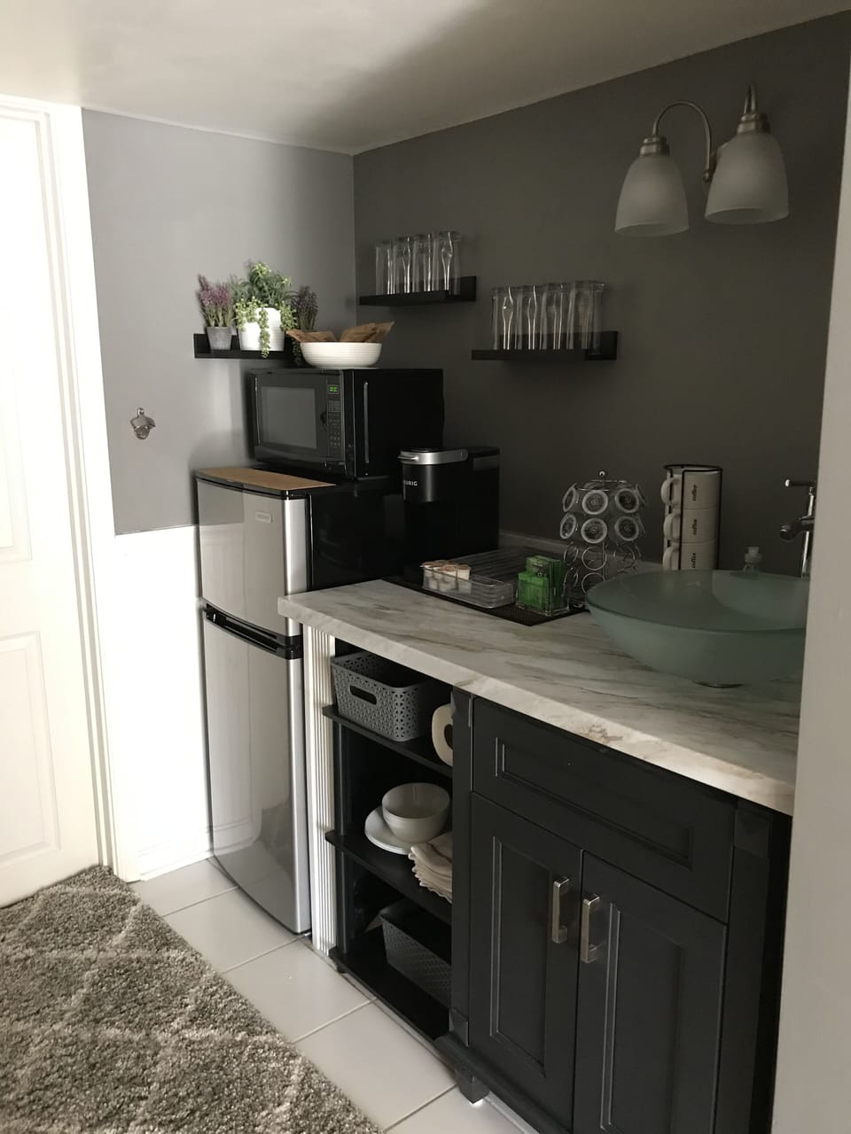 Kitchenette with cups, plates, bowls, and utensils
