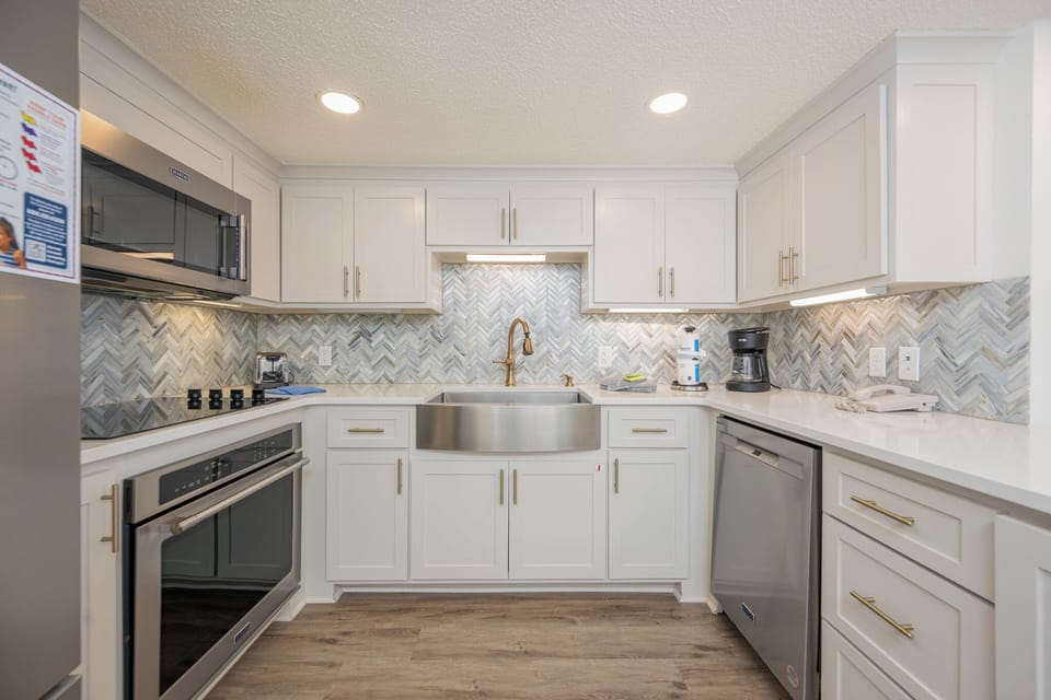 Modern kitchen features a spacious sink, modern cabinetry, and a stylish backsplash, creating an inviting cooking space