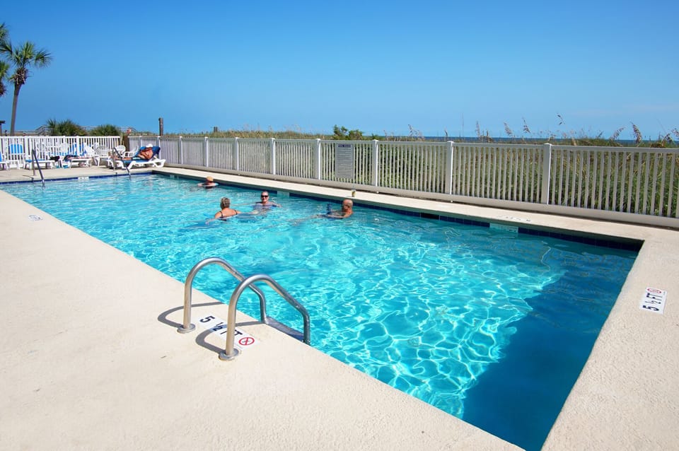 Swimming pool with sun loungers and a fenced deck at Crescent Sands K5 in Crescent Beach