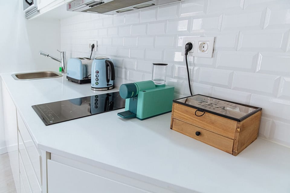 Kitchen equipped with kettle, toaster, coffee machine and microwave.