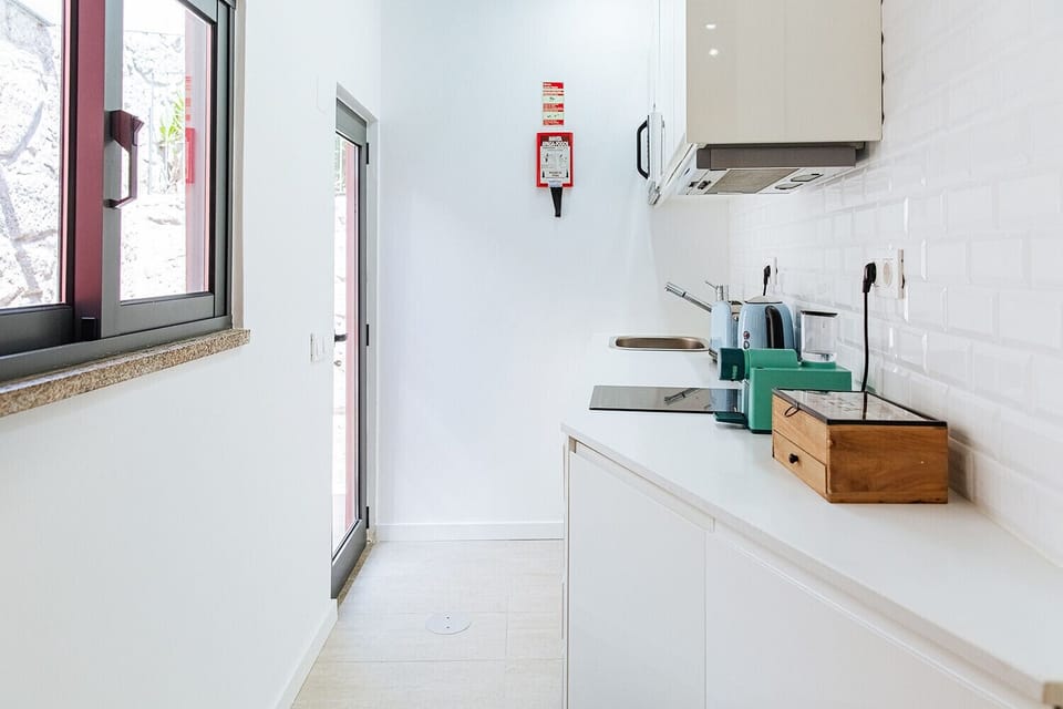Kitchen equipped with kettle, toaster, coffee machine and microwave.