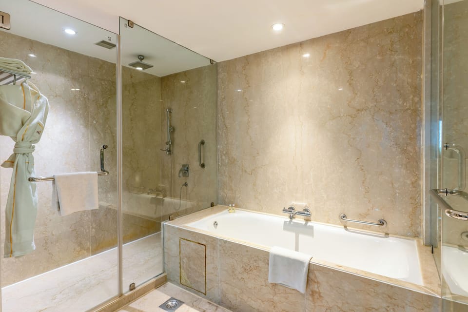 Suite, 1 King Bed | Bathroom | Combined shower/tub, rainfall showerhead, designer toiletries