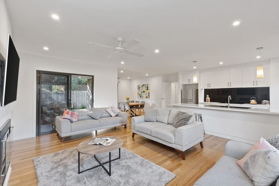 Light-filled and modern living room , open plan kitchen, lounge, and dining.