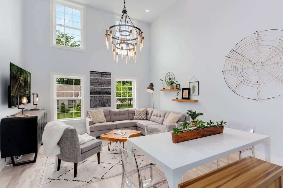 Welcome to our space, The Brownstone! With high vaulted ceilings & plenty of sleek seating areas, the living room is perfect for catching up, enjoying meals, and kicking back in front of our large 76-inch HDTV.