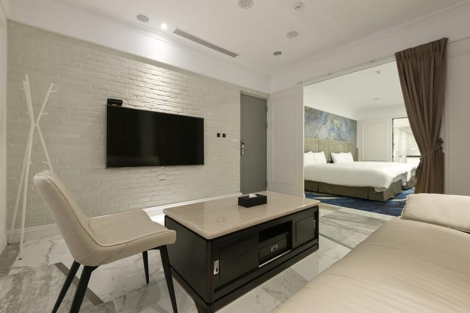 Deluxe Quadruple Room, Bathtub | Living area | 42-inch LCD TV with digital channels, TV