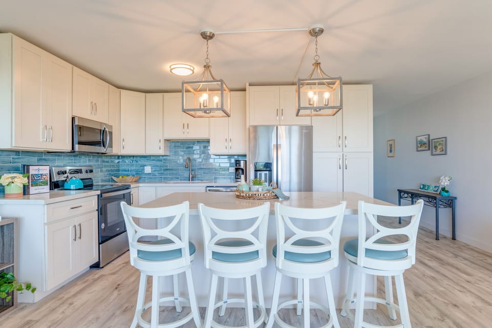 Large kitchen with over-sized island with bar stools.