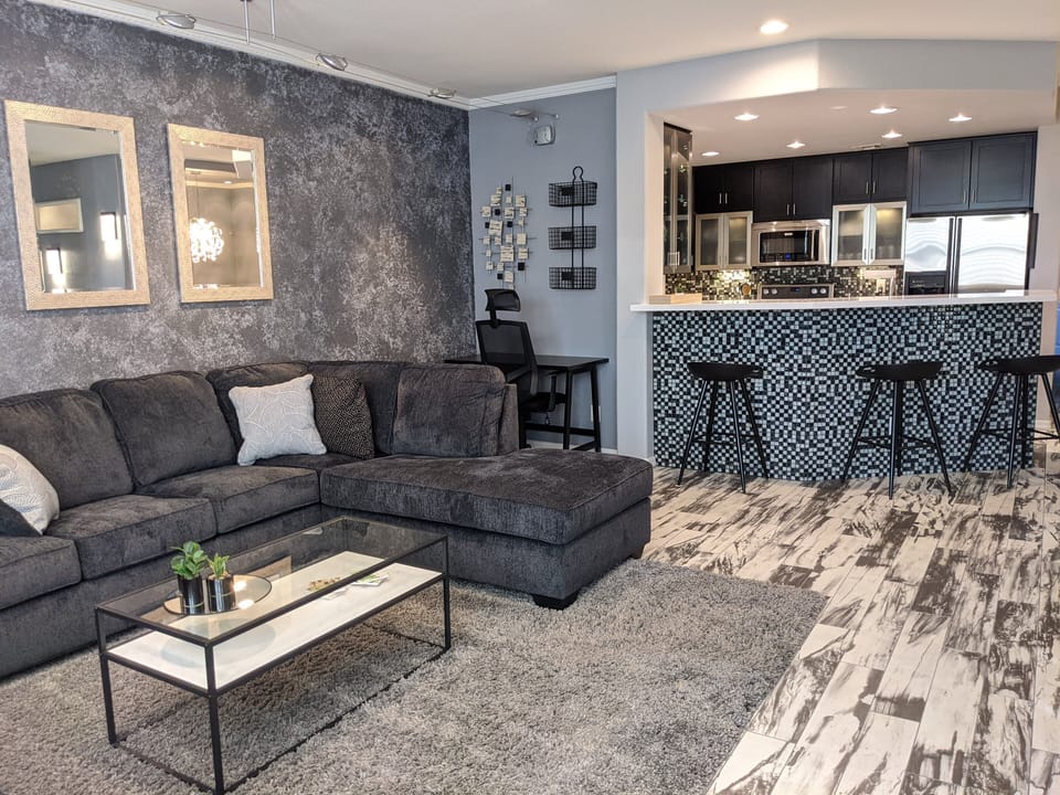 Open concept living space connects kitchen, dining, room, living room, & balcony