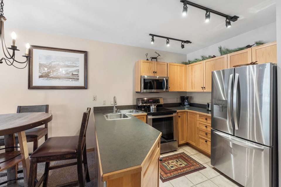 Your fully equipped kitchen awaits with stainless steel appliances, granite countertops, and warm wood cabinets - perfect for preparing memorable meals together.