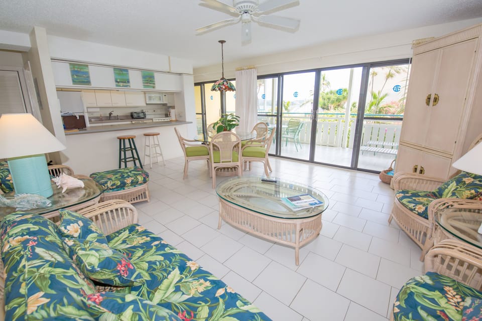 Living room looking through dining area & covered porch toward the pool & beach