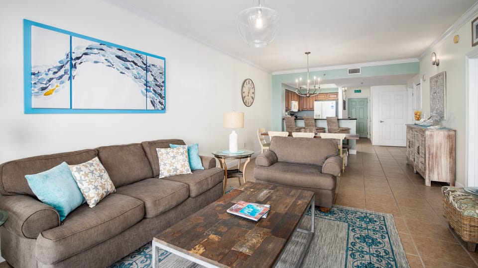 The living room offers a comfortable space to gather, whether you’re watching TV together or relaxing out on the balcony.