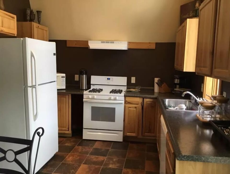 Modern kitchen area with all utensils and cook ware plus service for 12.