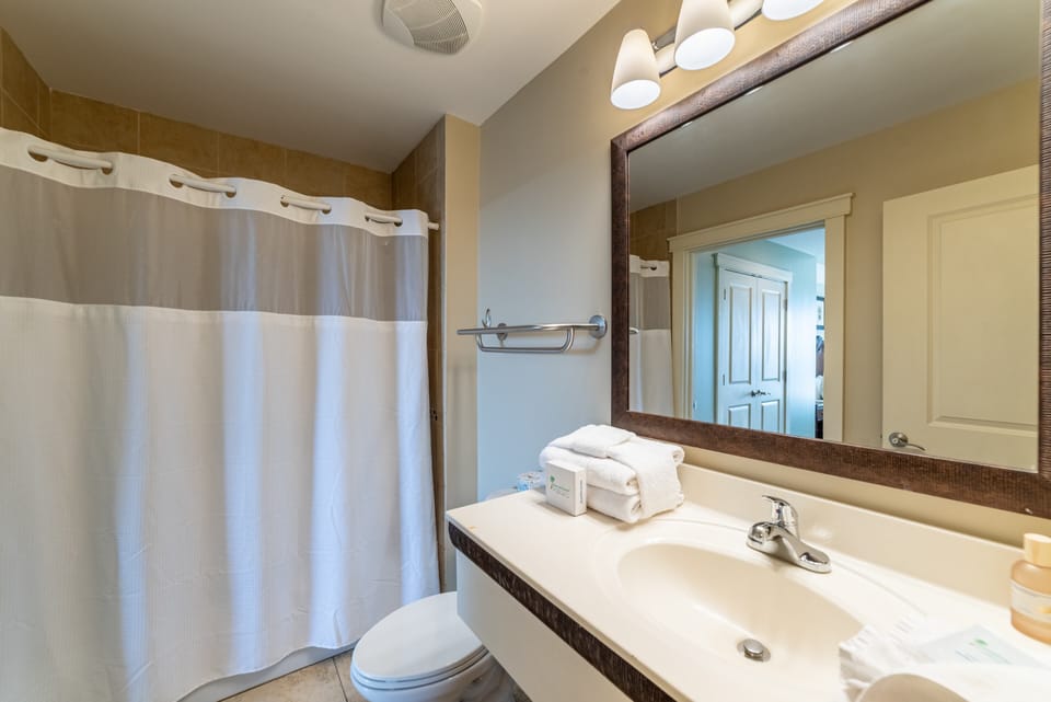 The bathroom offers a tub/shower combo, toilet, and single vanity with wall mounted hair dryer.
The bathroom can be accessed from the bedroom or the hallway