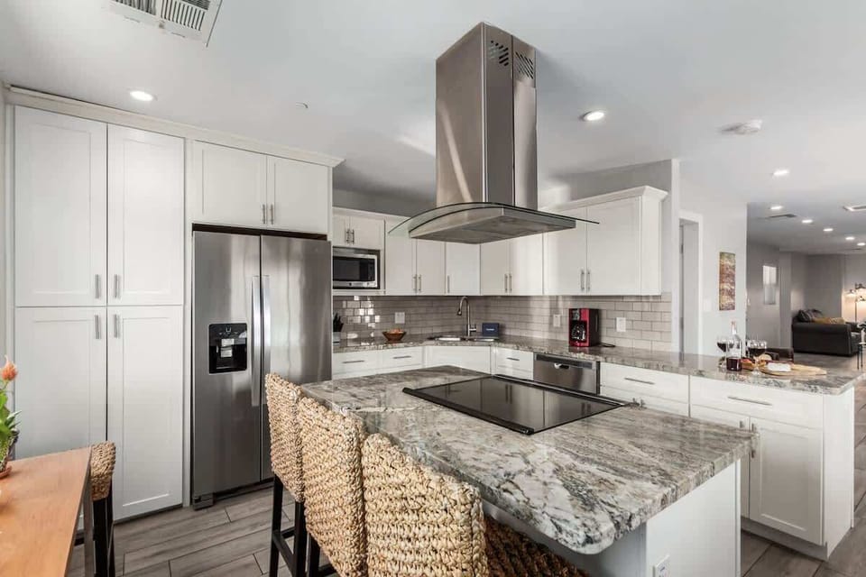Fully equipped kitchen boasting stainless-steel appliances, and an island with bar seating. Stocked with all culinary essentials for ease and convenience during your stay.