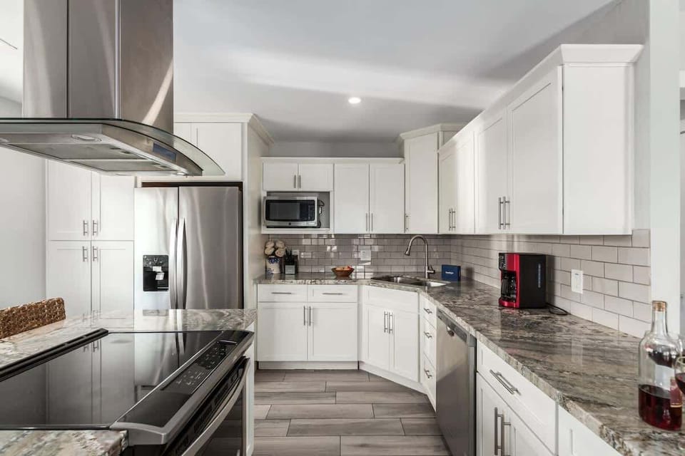 Fully equipped kitchen boasting stainless-steel appliances, and an island with bar seating. Stocked with all culinary essentials for ease and convenience during your stay.