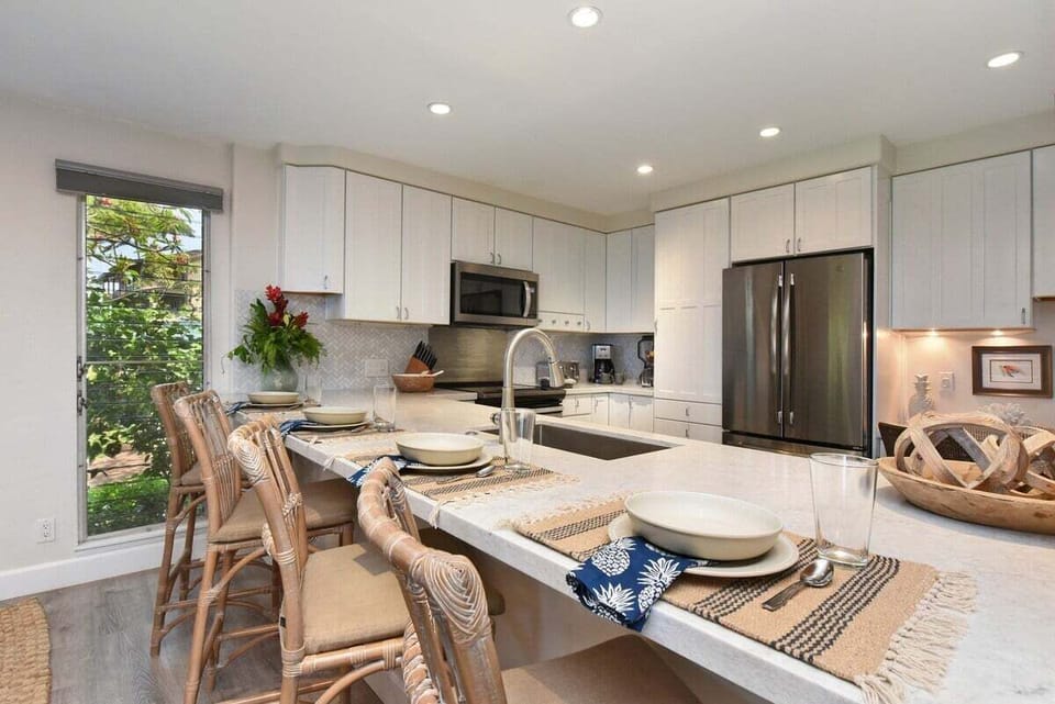 Modern kitchen with a spacious dining area featuring a wooden table and cushioned chairs, perfect for family meals or entertaining.