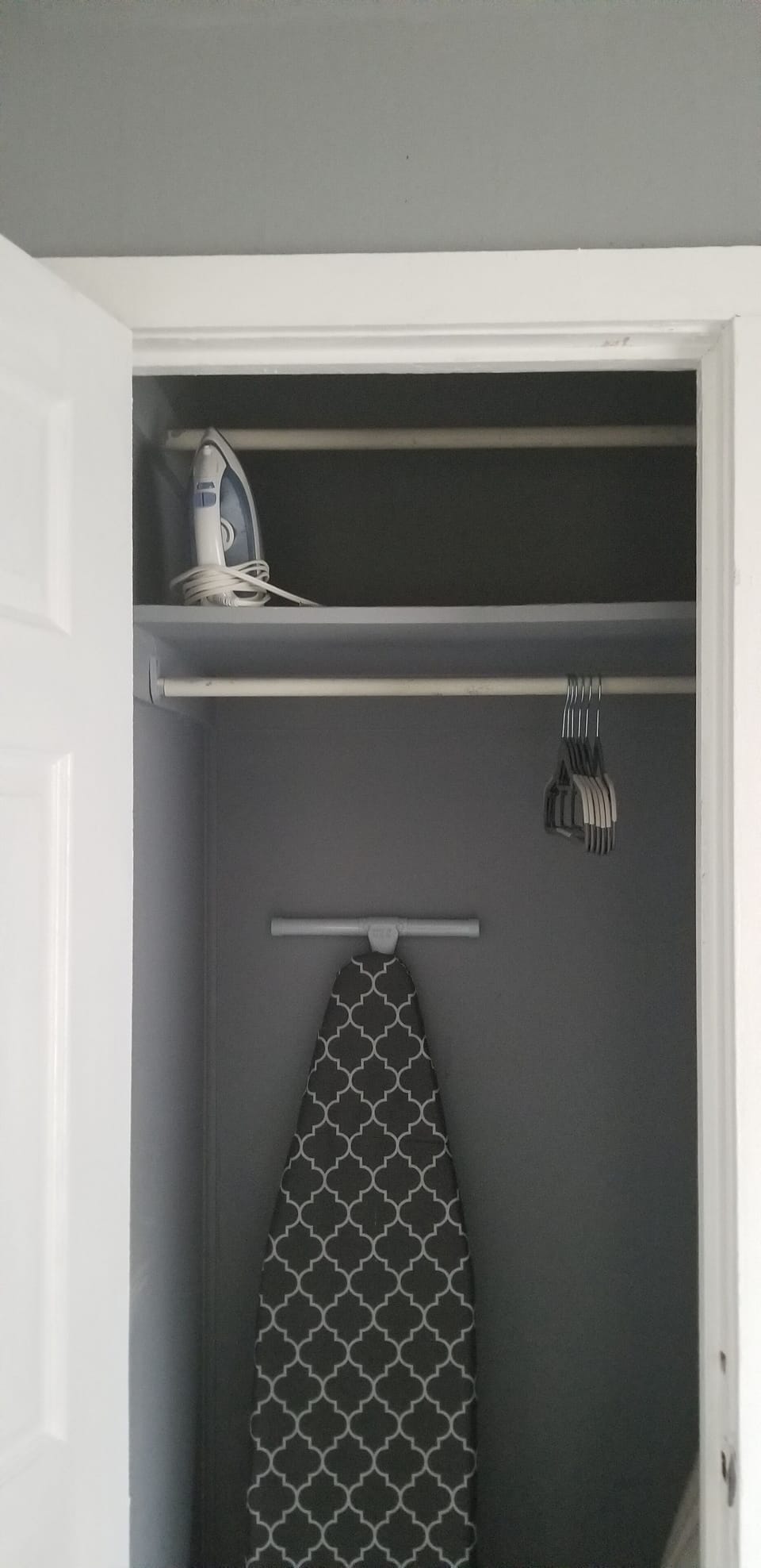 Iron and ironing board in the closet. All closets have hangers.