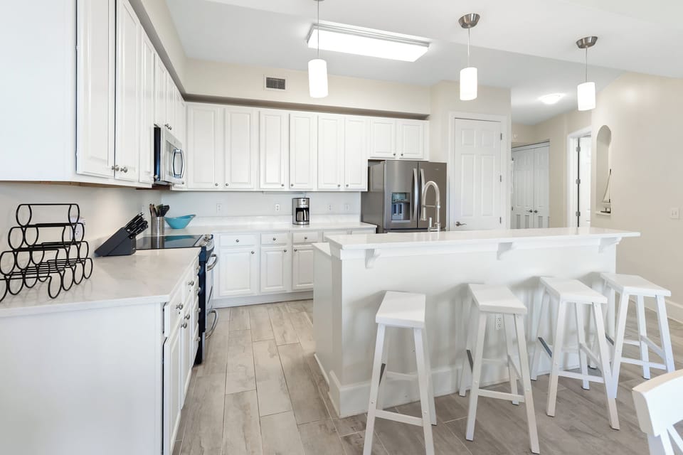 A bright, modern kitchen awaits with gleaming countertops, stainless appliances, and a spacious island—your perfect spot for morning coffee or gathering with loved ones over meals.