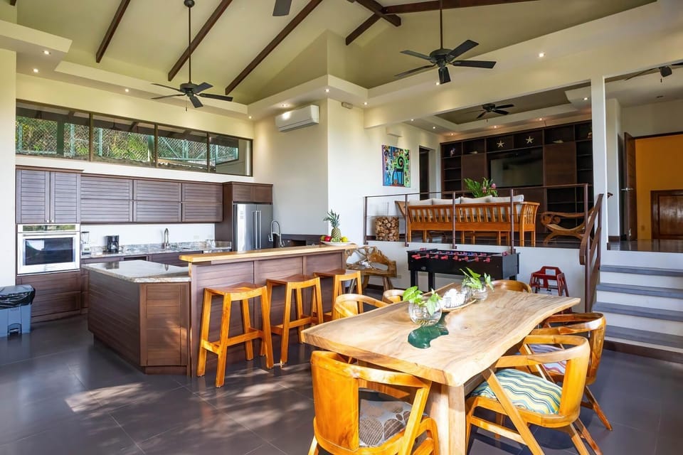 Open-plan living space combining kitchen, dining, and entertainment areas.
