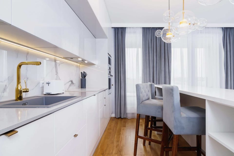 Kitchenette with kettle and refrigerator. 
