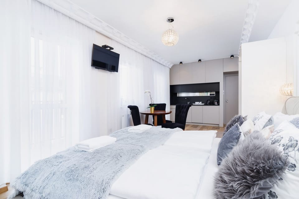 A bright bedroom area with soft furnishings and a large window letting in ample daylight.