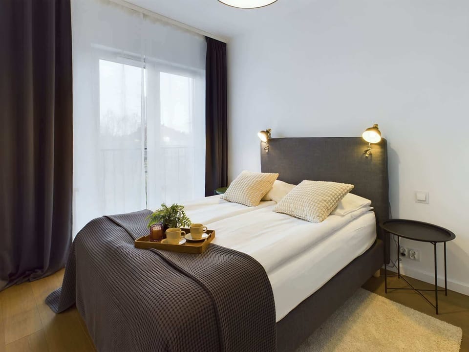 Another bedroom view featuring a double bed with a view out the window, letting in natural light and adding brightness to the room.