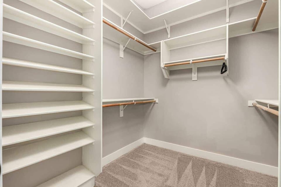 Primary Bedroom with King bed, smart TV, lounging area, large walk-in closet, access to the backyard, and en-suite bathroom.