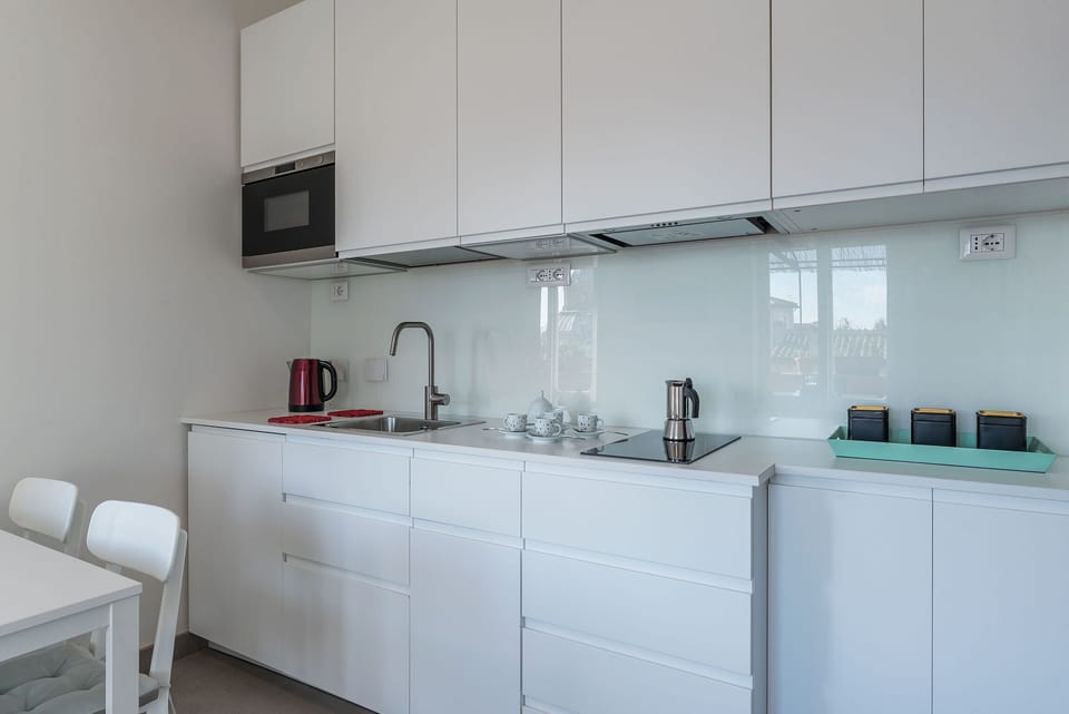 Deluxe Condo, 2 Bedrooms | Private kitchen | Full-size fridge, microwave, stovetop, cookware/dishes/utensils