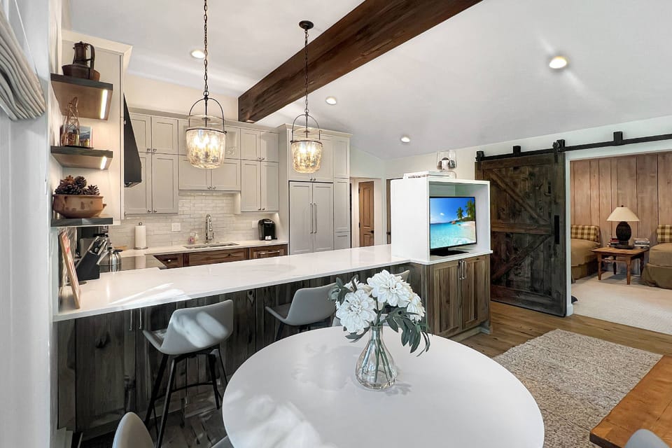 This vacation rental has a large living/dining area, full kitchen and a den with a barn door for privacy as a sleeping area.
