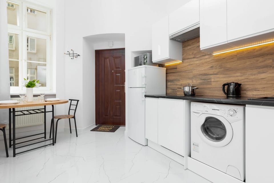 Kitchen with white cabinets and a wood-accented countertop, blending modern aesthetics and functionality.