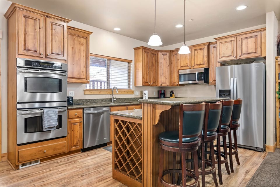 Kitchen with stainless appliances and island seating.