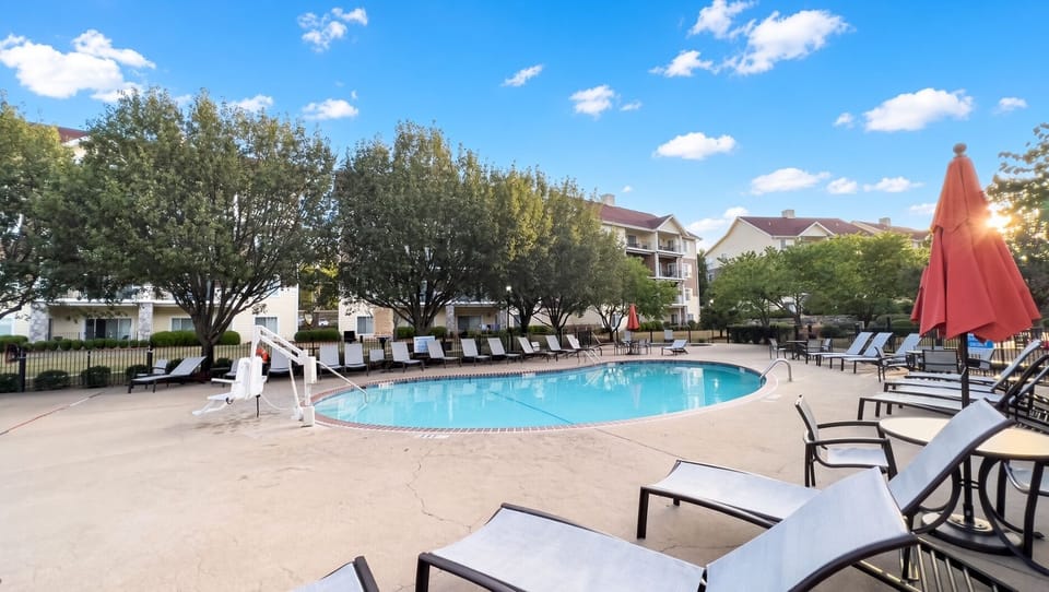 Outdoor Pool • Lounge Chairs & Resort Buildings