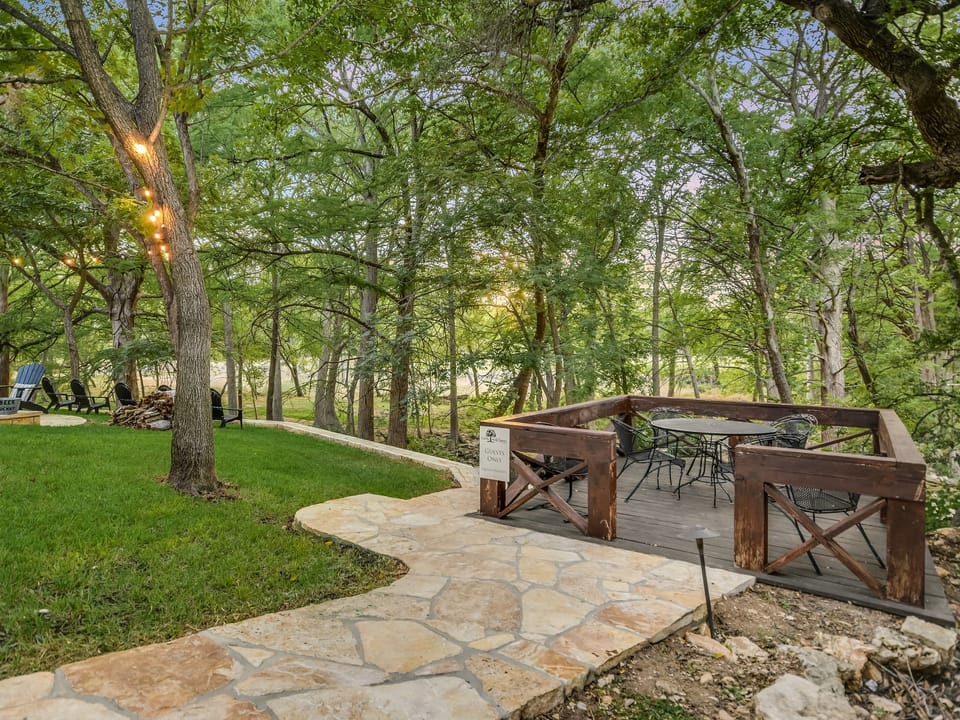 Shaded creekside table and lawn at Cabins on the Square