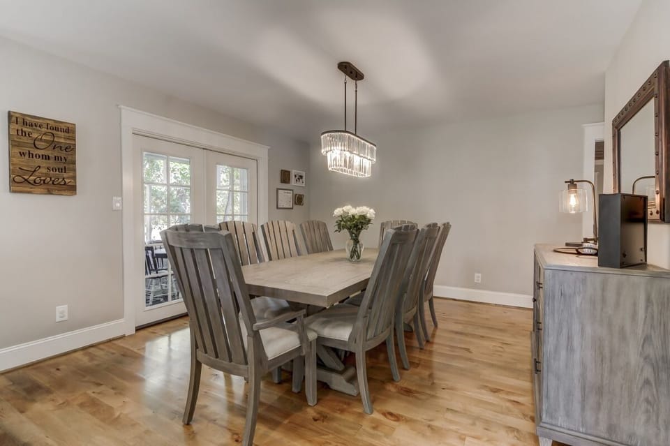 Dining room with french doors leading to screen porch with more dining