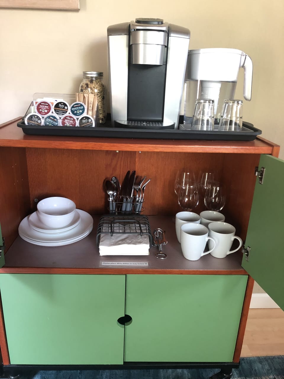 Keurig, generous assortment of pods and teas, granola, water, tableware.