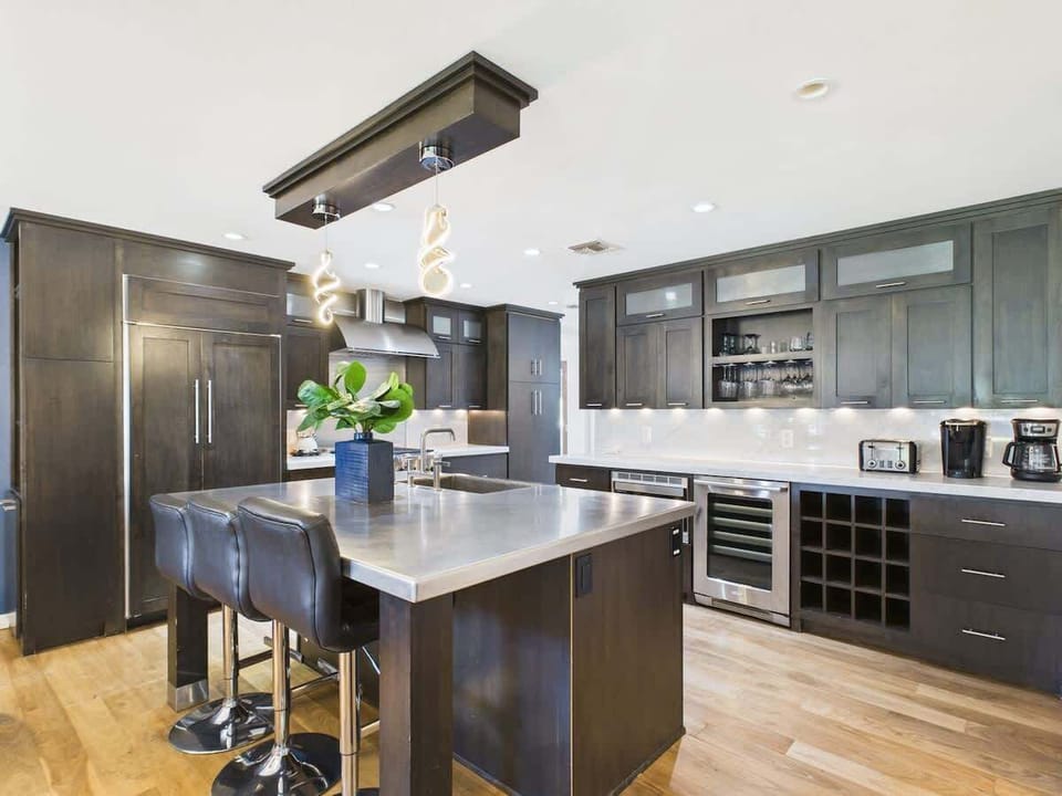 Fully equipped kitchen with stainless steal appliances and a kitchen island with bar seating for 3 guests.
