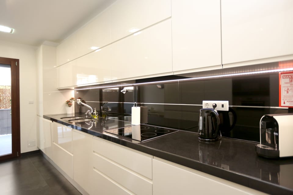 Cozinha ampla com mesa para pequeno almoço.