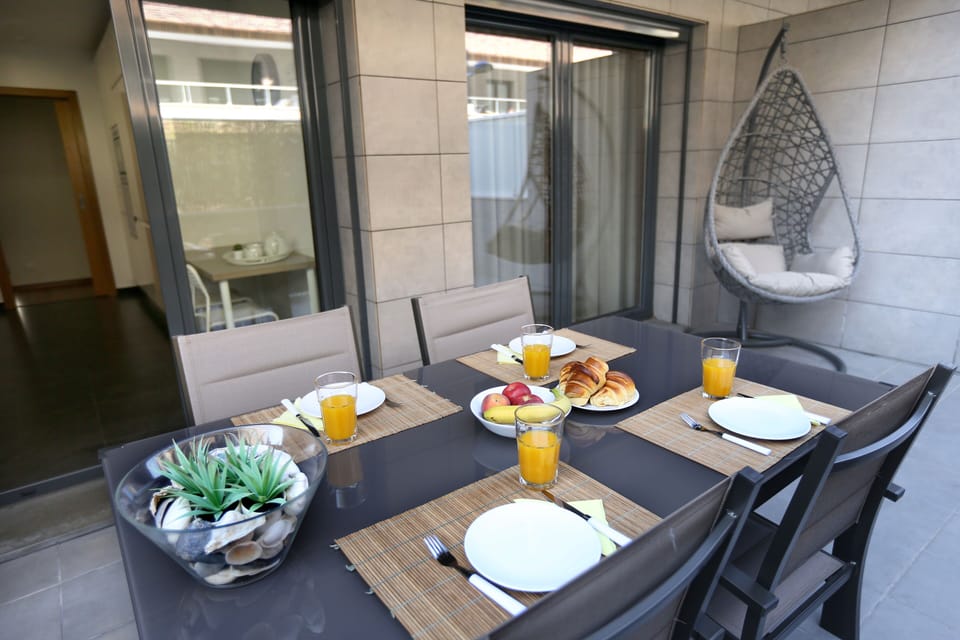 Terraço com mesa e cadeiras e cadeira de baloiço.