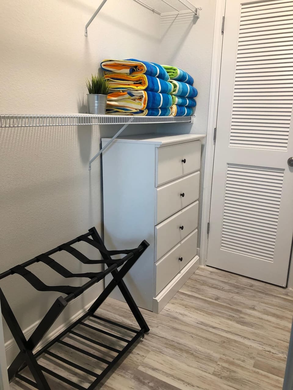 Large master walk in closet with luggage rack and 4-drawer dresser. 