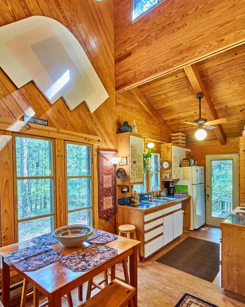 Cabin Dining room, thru full kitchen & back door to porch, deck, chiminea, creek bed & woods.