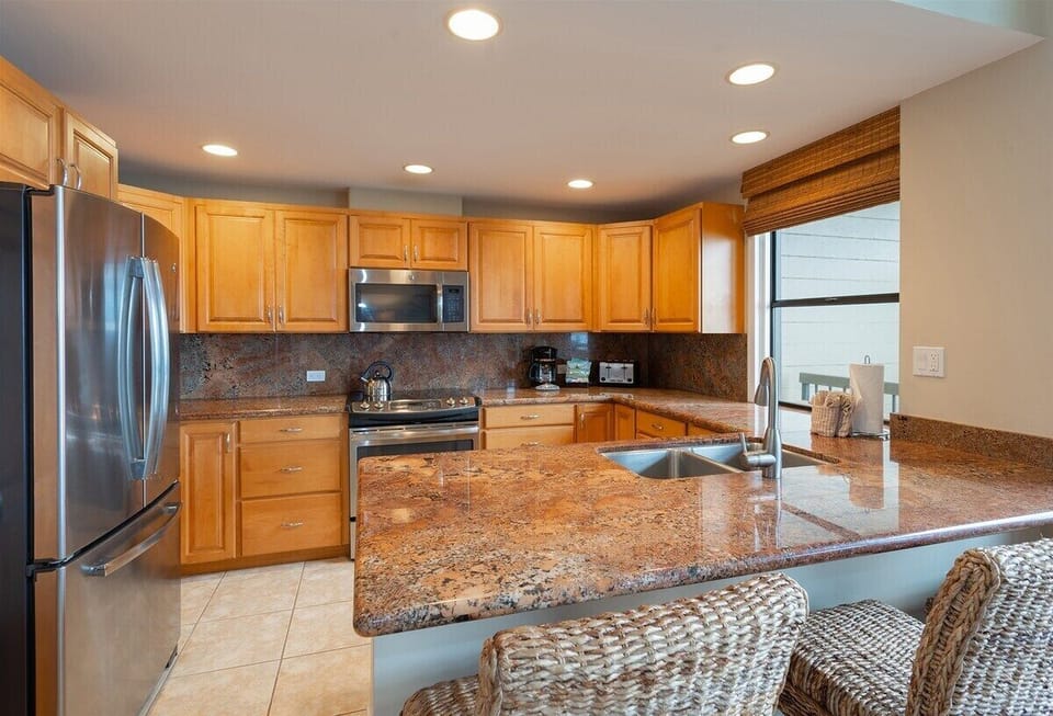The remodeled kitchen features all stainless-steel appliances, granite countertops and custom cabinetry