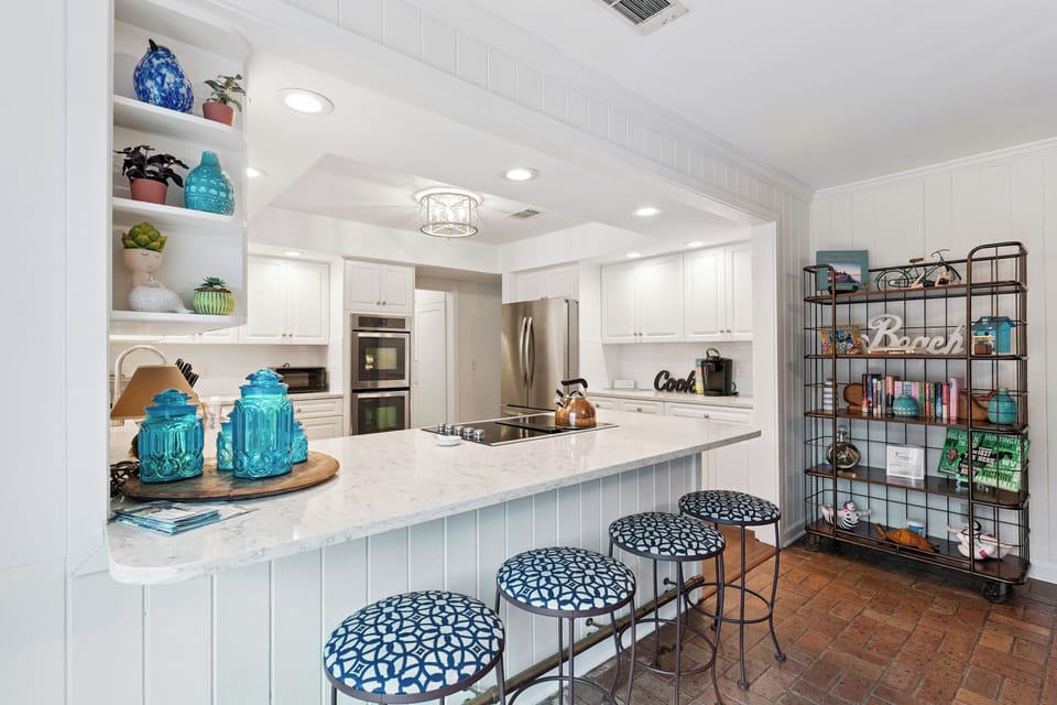 Your bright, modern kitchen features sleek white cabinets, granite counters, and stylish blue accents that create a perfect space for cooking.