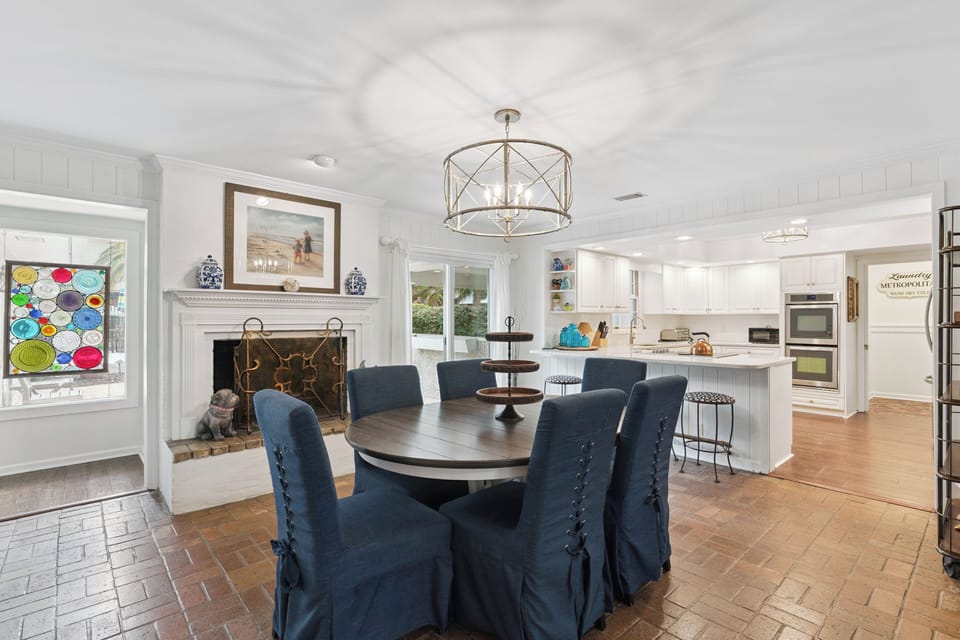Gather around this elegant dining table where your group can share memorable meals beside the cozy fireplace in this bright, open space.