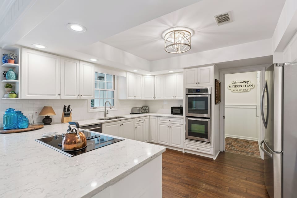 Step into your gourmet kitchen with gleaming white cabinets, marble counters, and chef-grade appliances perfect for creating memorable meals.