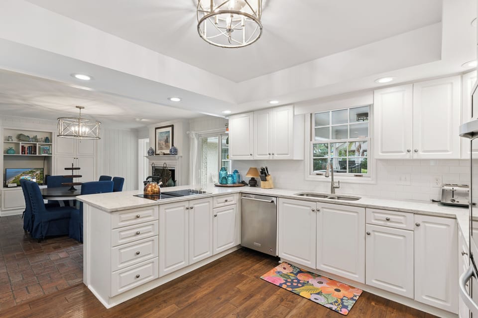 Step into your bright, airy kitchen where white cabinets and gleaming countertops create the perfect space for cooking memorable meals.