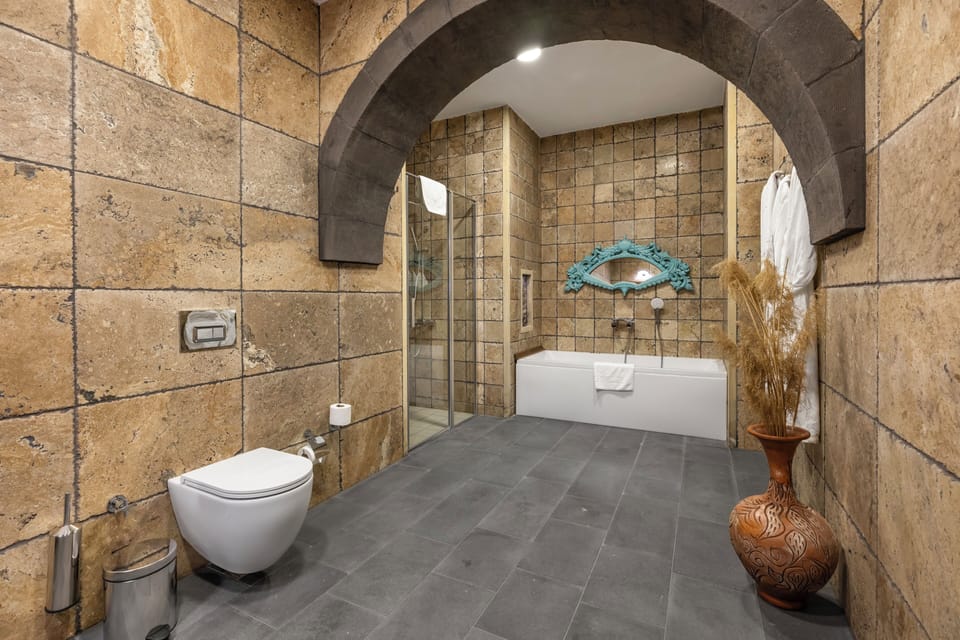 Deluxe Room (Cave) | Bathroom | Combined shower/tub, jetted tub, rainfall showerhead, free toiletries